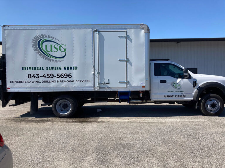 A white box truck wrap for Universal Sawing Group advertises concrete sawing and drilling services.
