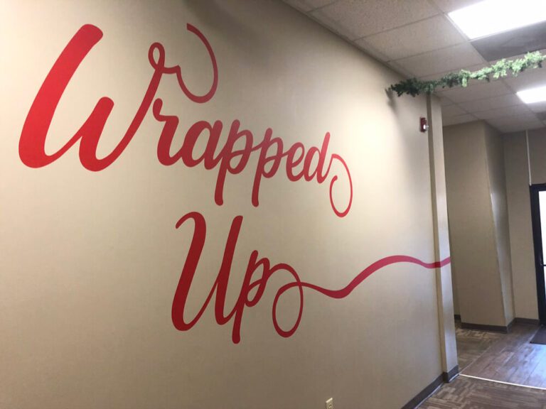 Retail wall graphic installation adding vibrant promotional visuals to space