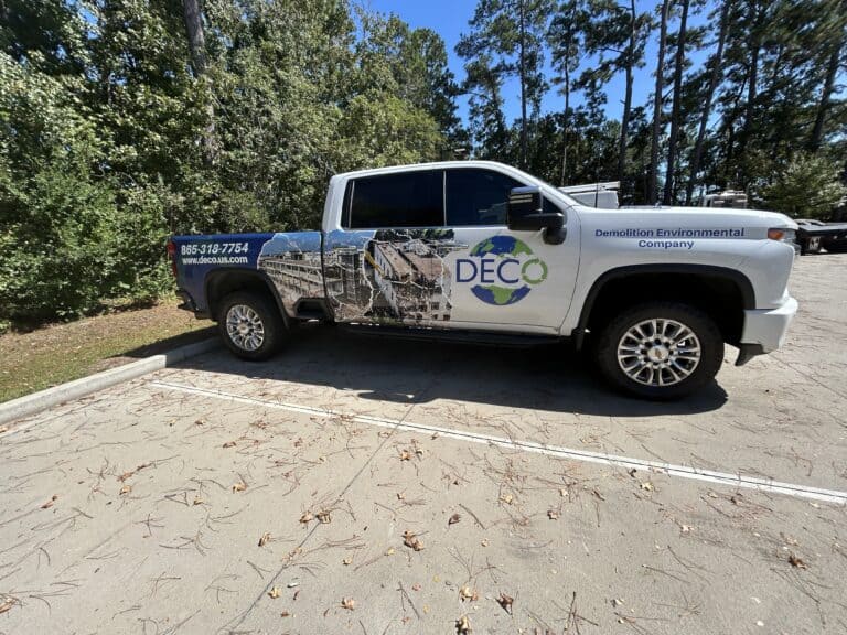 Vehicle wrap showcasing Deco Environmental's branding and contact info.