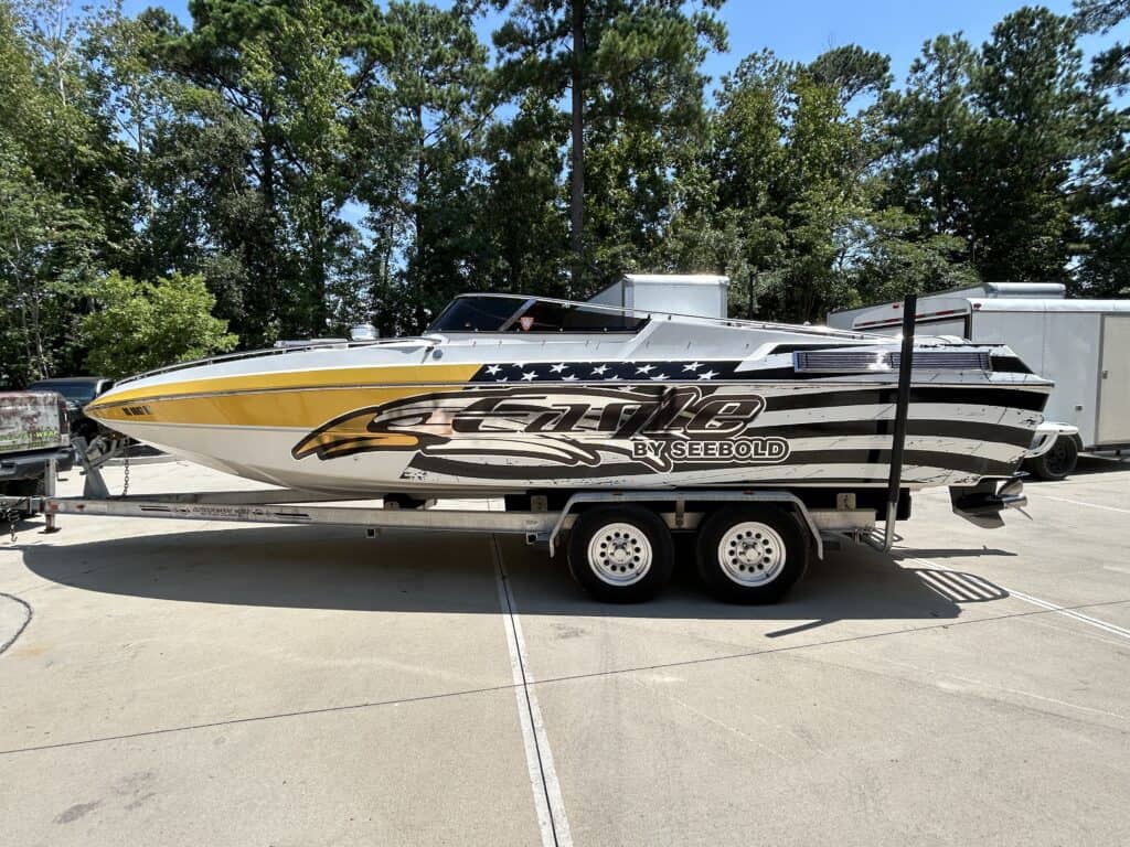 Speedboat with custom black, white, and yellow wrap featuring bold graphics and branding.