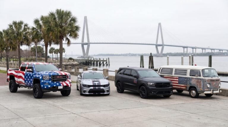 A pickup truck, a sedan, an SUV, and a van show different patriotic wrap designs with the Ravenel Bridge behind them.